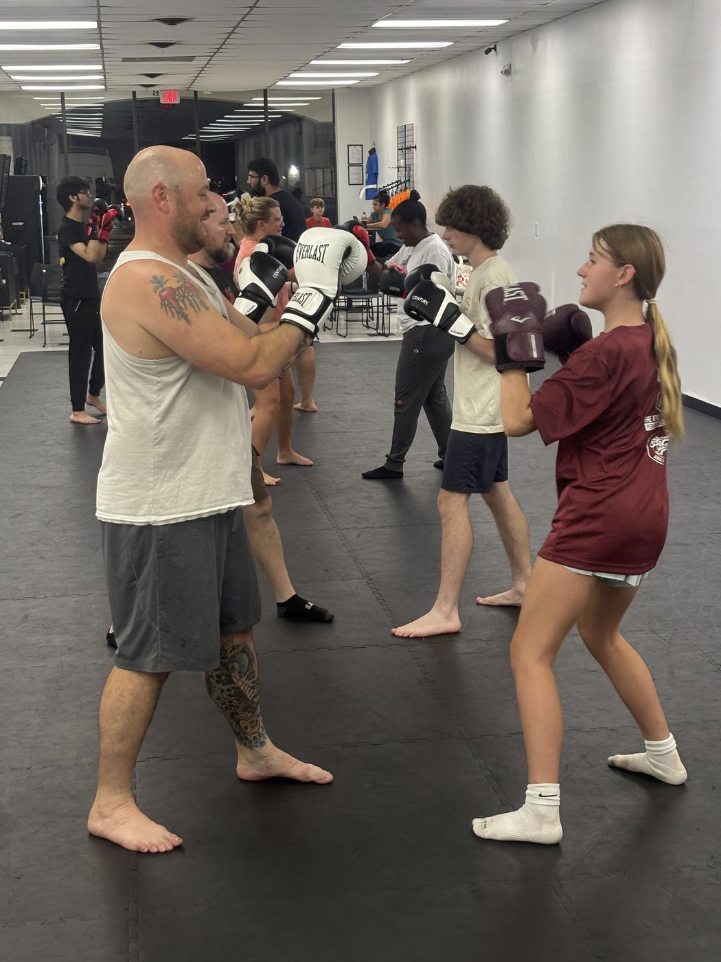 Teens and adults of different ages and fitness levels training together in an adult kickboxing class in Salisbury, MD
