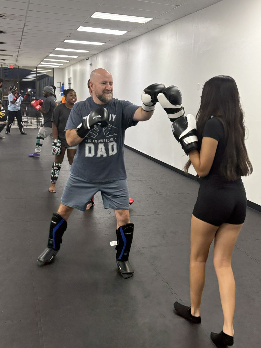 Two adults in gloves and shin guards working a controlled partner drill at Legacy Martial Arts
