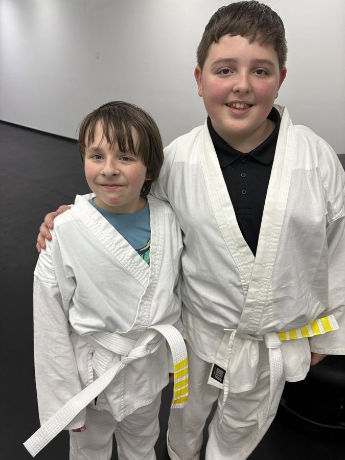 Two Legacy Martial Arts students after earning belt stripes
