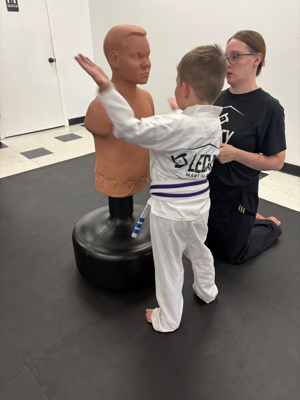 An instructor coaching a young student one-on-one at Legacy Martial Arts