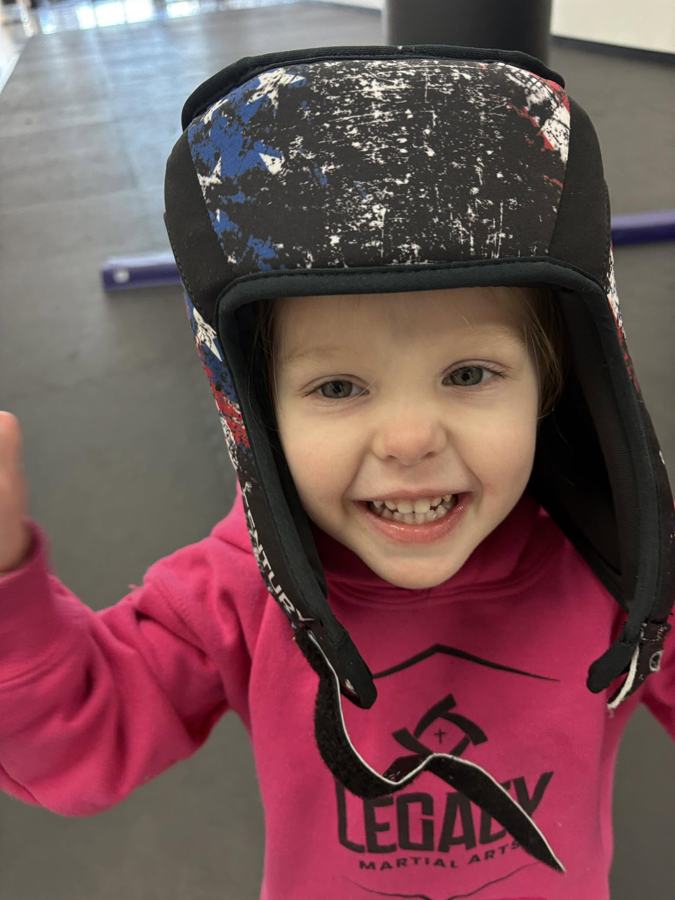 A young Legacy Martial Arts student in sparring headgear